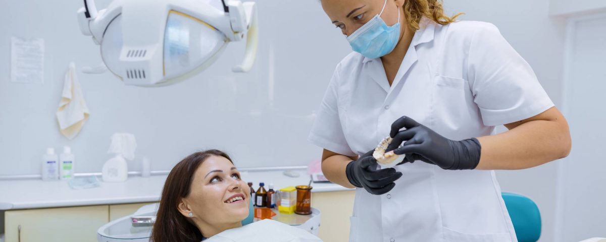dentysta pokazuje jak dbać o implanty zębów po zabiegu wszczepienia