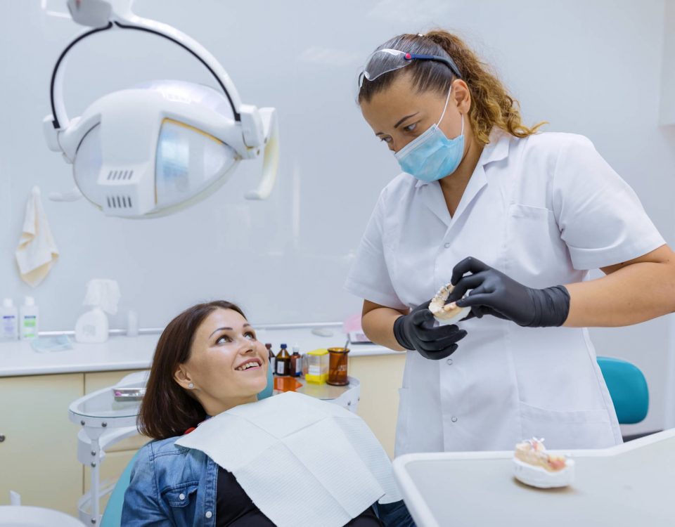 dentysta pokazuje jak dbać o implanty zębów po zabiegu wszczepienia
